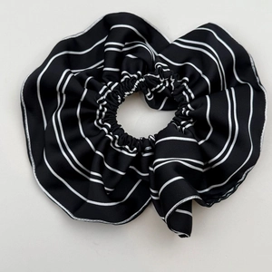 Detailed view of large black and white striped hair scrunchie with soft satin finish