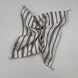 Detail view of striped silk scarf featuring elegant teardrop pearl corner pendants