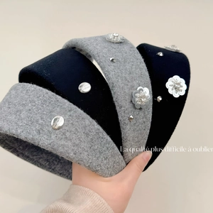 Close-up of wool headband with silver sequin flowers and engraved metal tag