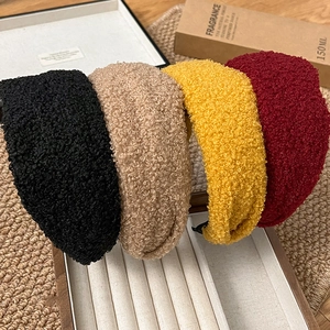 Gros plan de serre-têtes épais en laine sherpa noire, beige, jaune et bordeaux