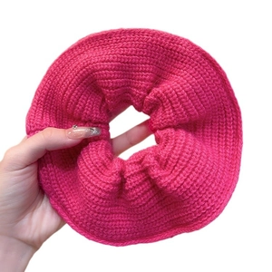 Oversized rose pink cable knit scrunchie hair tie held in hand for scale