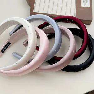 Detail of satin headbands with silver rhinestones in five colors on a wooden display