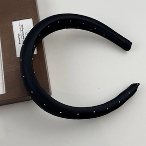 Detail of black satin headband featuring silver studded rivets for a premium hair style