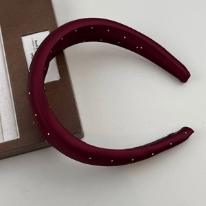 Detail of burgundy satin padded headband featuring delicate silver metal stud embellishments