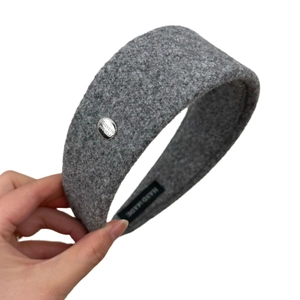 Elegant grey woolen headband with decorative metal plate and handcrafted interior label