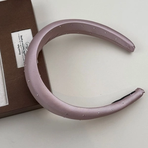 Detail of mauve satin padded headband with silver studs and non-slip lining