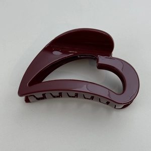 Close-up of deep red hollow heart hair claw clip with high gloss finish and sturdy teeth