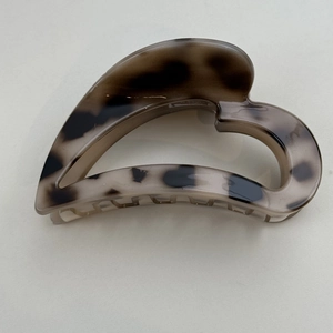 Detail view of heart-shaped hair claw clip with vintage tortoiseshell texture pattern