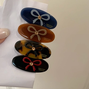 Oval acetate hair clips with crystal bows in navy, amber, tortoiseshell and black colors