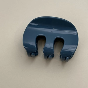 Vue de dessus d'une pince à cheveux française bleu foncé brillant au design en M