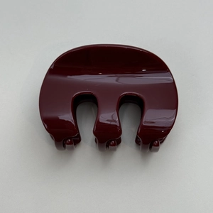 Vue détaillée de la pince à cheveux en résine bordeaux brillante avec design à trois dents
