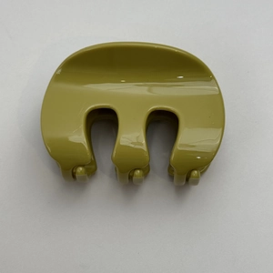 Vue détaillée de dessus d'une pince à cheveux vert olive en forme de m sur fond blanc