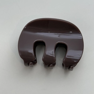 Close-up of a glossy dark coffee brown hair claw clip with smooth resin surface