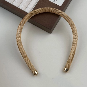 Vue détaillée du serre-tête en métal tressé doré avec une finition en maille texture