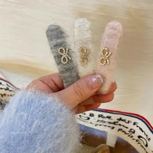 Three-piece set of plush bow hair clips in grey white and pink with rhinestone centers