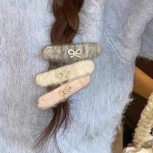 Three plush bow hair clips in grey, beige, and pink with rhinestones on a braid