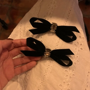 Detail of vintage black velvet bow hair clips with emerald-cut crystals decoration