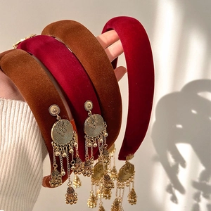 Close-up of velvet padded headband featuring ethnic golden bell tassels and fringe detail