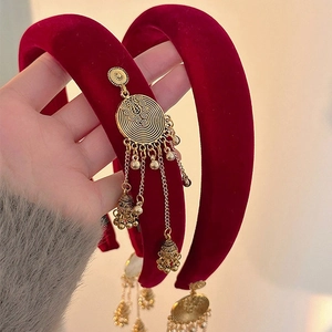 Close-up of velvet headband with golden filigree bells and bohemian style tassels