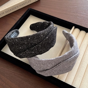 Foldable wide sparkling fabric headbands in black and grey on a jewelry tray