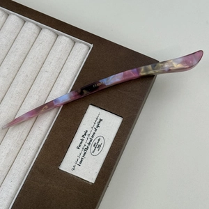 Detail of French handmade acetate hair pin with purple and gold marble texture