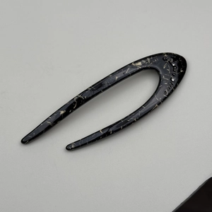 Detail of a black marble texture U-shaped hair pin with sparkling rhinestone accents