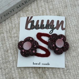 Detailed view of handmade red sequin flower clips and bow hair accessories for girls