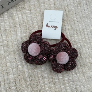 Close-up of sparkling red sequin flower hair ties with pink velvet center for girls