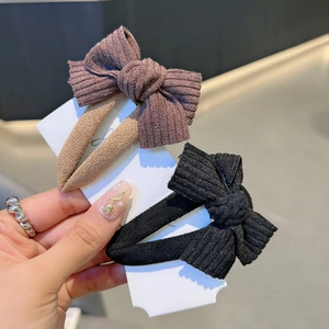 Elegant fabric bow hair clips in purple and black colors displayed on a white product card