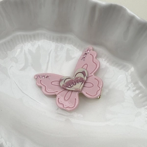 Détail de la pince à cheveux papillon rose avec cœur LOVE et strass brillants