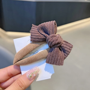Elegant purple fabric bow hair clip with ribbed texture on a white display card