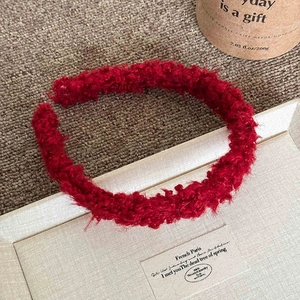 Détail d'un serre-tête rouge en laine d'agneau avec texture peluche pour mode hivernale