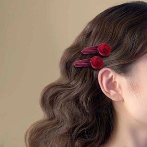 Elegant pair of vintage red velvet rose hair clips on model for French retro style