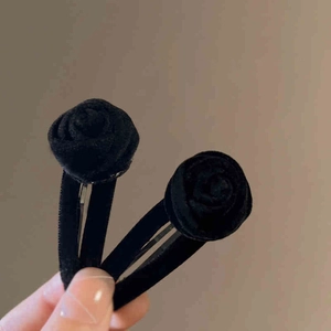 Close-up detail of a vintage black velvet rose hair clip on a sturdy metal BB clip base