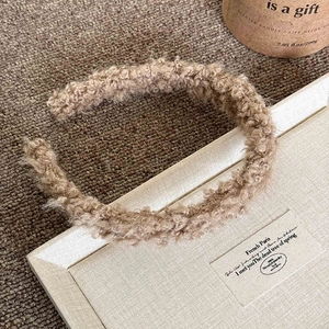 Détails de texture d'un serre-tête en laine d'agneau marron clair pour styles d'hiver