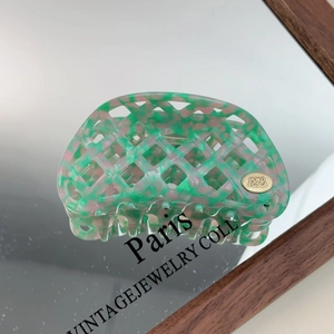 Detail of waffle hollow hair claw clip with green and pink checkerboard pattern