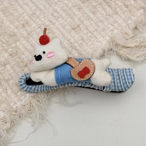 Close-up of cute plush bear hair claw with blue striped shirt and cherry detail