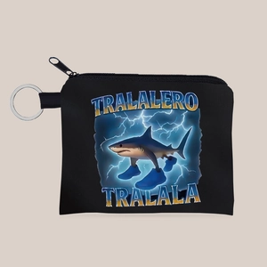 Dettaglio del portamonete in tela nera con illustrazione di squalo e portachiavi argento