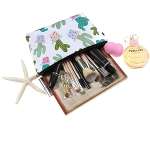 Cactus print makeup bag with multiple brushes and cosmetics inside on white background