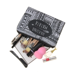3D black and white geometric Hakuna Matata makeup bag with cosmetics on white background