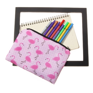 Pochette trucchi rosa con fenicotteri e astuccio con cerniera nera sulla scrivania