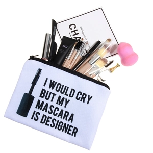 White canvas makeup bag with mascara slogan and beauty tools on white background
