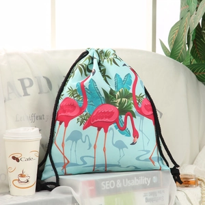Close-up of drawstring backpack with flamingo and tropical leaf print on light blue canvas