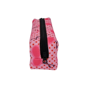 Detail view of pink flamingo print makeup bag with red polka dots and black zipper closure
