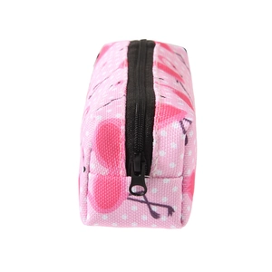Detail view of pink flamingo print makeup bag with white polka dots and zipper closure