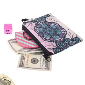 Close-up of mandala pattern coin purse with metal zipper ring and canvas texture