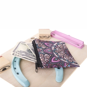 Mandala print coin purse with zipper closure on a light wood background setting