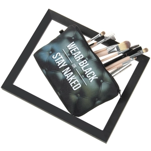 Macro detail of a black cosmetic bag with white slogan and multiple professional brushes