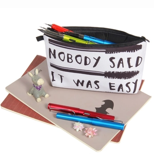 Detail of the white makeup bag featuring black letter print and a sturdy top zipper