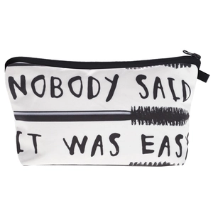 Macro view of white canvas makeup bag featuring black letter print and zipper closure